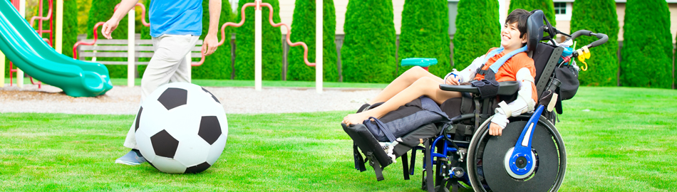 Image of soccer ball, adult legs and child in wheel chair Image of soccer ball, adult legs and child in wheel chair